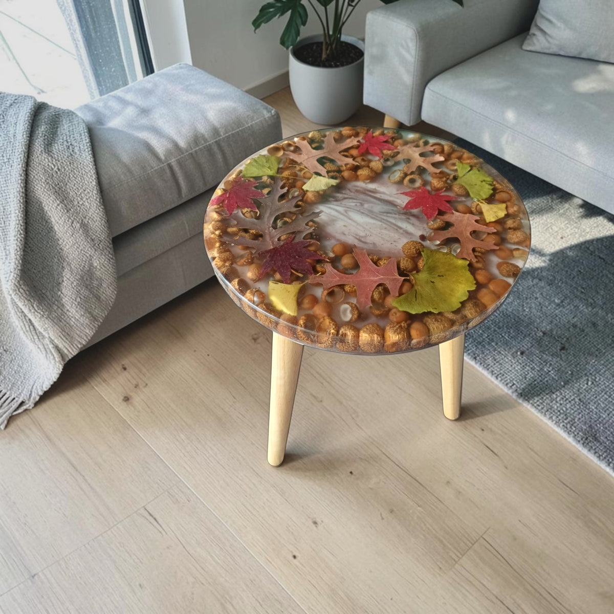 Autumn leaf resin side table styled as a living room accent table beside a sofa (digital visualization)